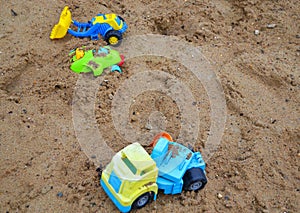 an abandoned children's toy truck inside a sand pit, a children's playground.