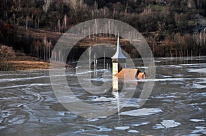 Abandoned church in a mud lake. Natural mining disaster photo