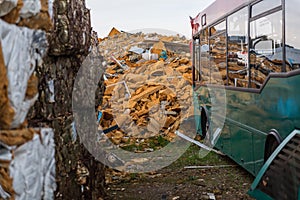 Abandoned city bus in a junkyard close to a orange insulating foam mountain