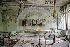 Abandoned class room with furniture and debris in Pripyat