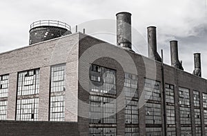 Abandoned coal power plant with broken windows, excess coal and worn, rusted exterior. Coal power plants are being phased out