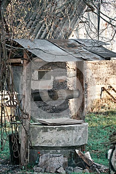 Abandoned concrete well in the courtyard of the village, morning