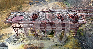 Abandoned copper mine with rusty trolleys and rails, aerial view