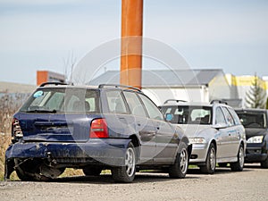 Abandoned and damaged vintage cars in a service