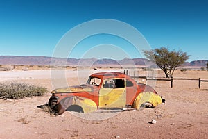 Abandoned derelict old car in the sandy desert