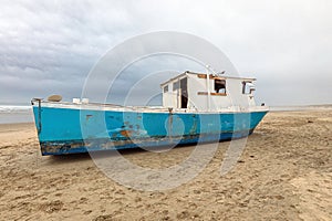 Marooned Fishing Boat Abandoned on the Oregon Coast Beach photo