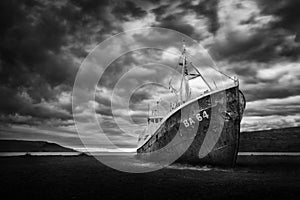 Abandoned desolate rusty ship in black and white color