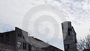 Abandoned and destroyed building of the old factory. Post-apocalyptic landscape. Broken windows