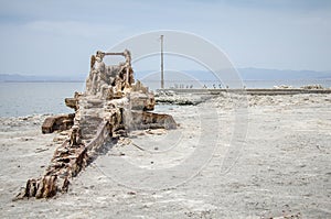 Abandoned dredge equipment sits on the beach, covered in salt and debris at the Salton Sea