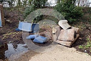 Abandoned and Dumped Sofa Armchair at the Garages Flytipped in the Rain