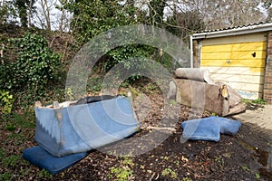 Abandoned and Dumped Sofa Armchair at the Garages Flytipped in the Rain