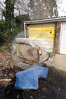 Abandoned and Dumped Sofa Armchair at the Garages Flytipped in the Rain