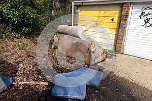 Abandoned and Dumped Sofa Armchair at the Garages Flytipped in the Rain