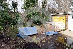 Abandoned and Dumped Sofa Armchair at the Garages Flytipped in the Rain