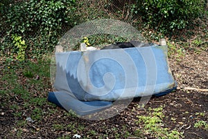 Abandoned and Dumped Sofa Armchair at the Garages Flytipped in the Rain