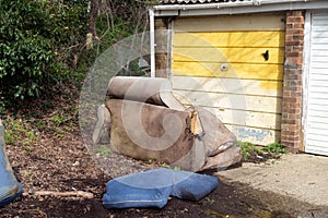 Abandoned and Dumped Sofa Armchair at the Garages Flytipped in the Rain