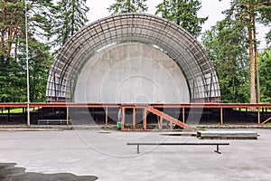 Abandoned empty aerial summer theater, stage in the park. Old building