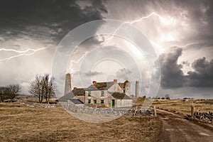 Abandoned empty rural stone cottage in Peak District near to old deserted ancient mine workings with dramatic big lightning storm.