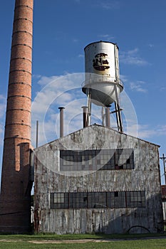 Abandoned factory building with water tower and chimney