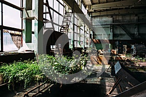 Abandoned factory inside, big windows, rusty steel equipment