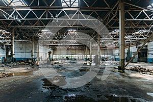Abandoned factory. Large empty ruined industrial hall with broken remnants of equipment