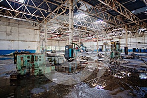 Abandoned factory. Large empty ruined industrial hall with broken remnants of equipment