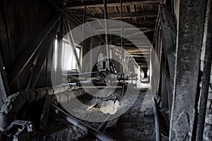 Abandoned factory. Old dusty band conveyer in old corridor of reinforced concrete plant