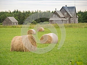 Abandoned farm house and bales of hay