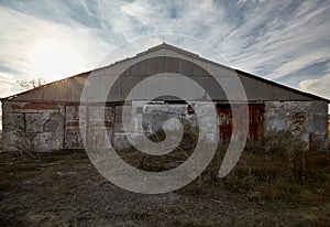 Abandoned farm outside, overgrown with grass, early autumn.