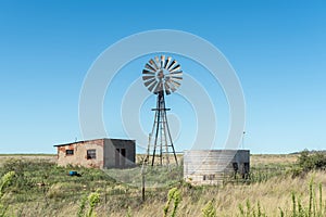 Abandoned farm worker house, windmill and dam