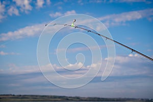 The abandoned feeder rod in a summer day on the river