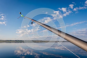 The abandoned feeder rod in a summer day on the river