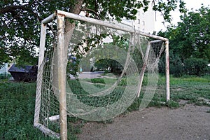 Abandoned football field, goal with a torn net in a vacant lot