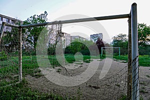 Abandoned football field, goal with a torn net in a vacant lot