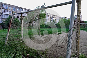 Abandoned football field, goal with a torn net in a vacant lot