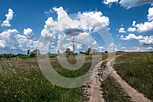 Abandoned Gravel Road Through Rural Landscape With Electricity Pylons And Wires In Hungary