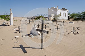 Abandoned graveyard with crumbling stones and crosses in Namib Desert of Angola