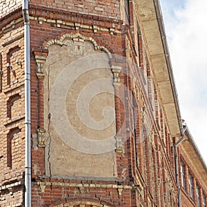 Abandoned grunge cracked red brick building.