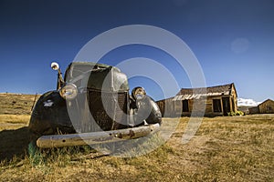 Abandoned historical car with main headlights and front grill