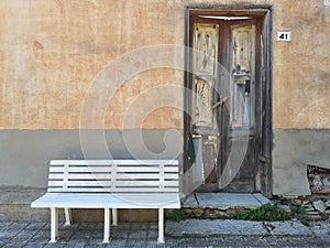 Abandoned house with pristine white bench