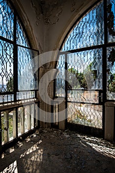 Abandoned house room with view through broken windows and doors