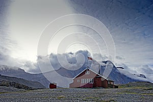 Abandoned hut in front of cloudy mountains