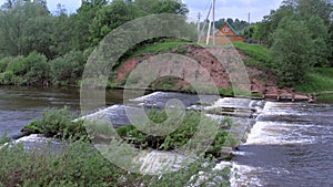 Abandoned hydroelectric power station on river waterfall with streaming current.