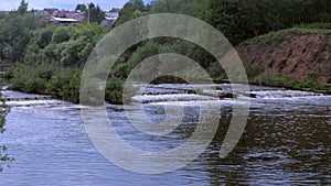 Abandoned hydroelectric power station on river waterfall with streaming current.