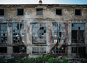 Abandoned industrial building facade, broken windows, shabby walls