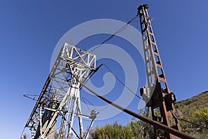 Abandoned industrial coal mining steel structure tower from cableway with cable in Tormaleo Asturias province of Spain on a bright