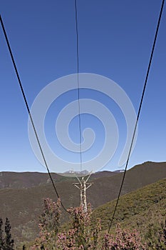 Abandoned industrial coal mining steel structure tower from cableway with cable in Tormaleo Asturias province of Spain on a bright