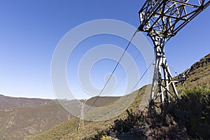 Abandoned industrial coal mining steel structure tower from cableway with cable in Tormaleo Asturias province of Spain on a bright