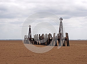 Abandoned landing stage at saint annes pier in the ribble estuary lancashire at low tide with grey clouds