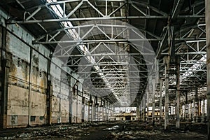 Abandoned large industrial hall or warehouse with garbage, manufactory factory